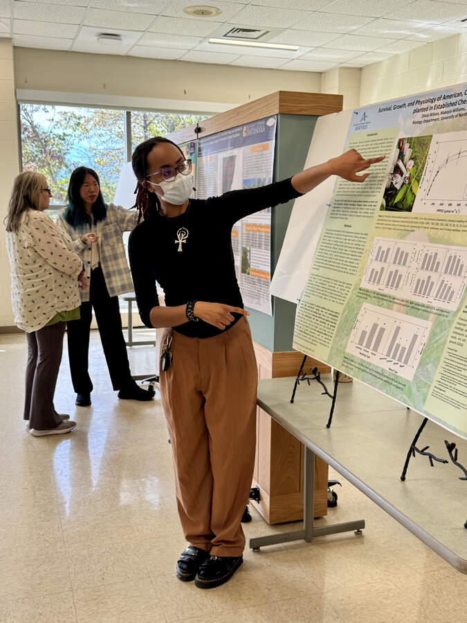 Olivia Wilson presenting her poster. Sky Lu, behind, presenting her poster.