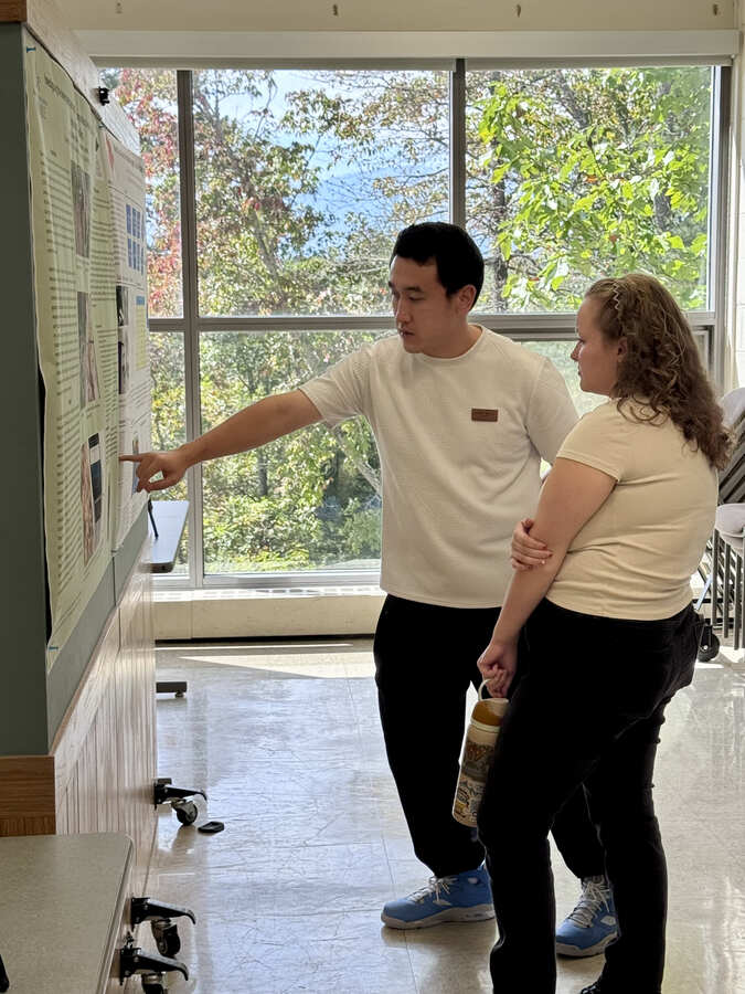 Roger Zhang describing his poster to Mick Williams.