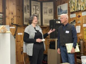 Two speakers stand at the front of a room