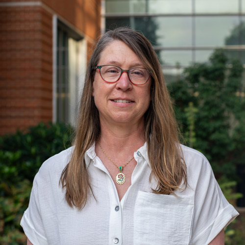 Woman with white linen shirt and glasses. Headshot of Stacy Byrd.